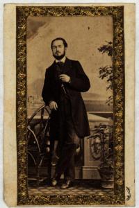 Ritratto maschile - Uomo con barba e baffi, in piedi vicino a una sedia
