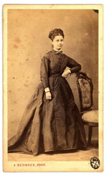 Ritratto femminile - Donna con acconciatura raccolta, in piedi accanto a una sedia