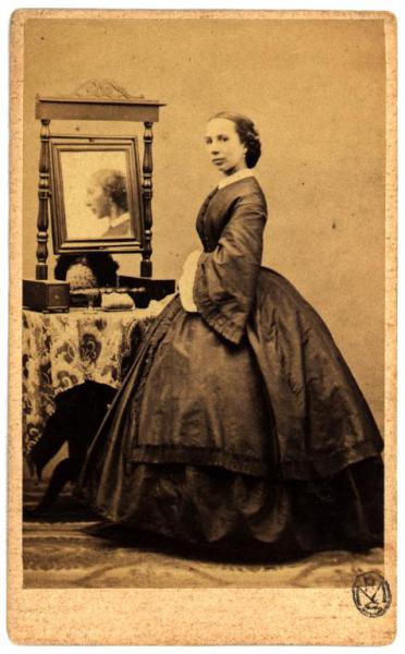 Ritratto femminile - Donna in piedi davanti a un tavolo con uno specchio