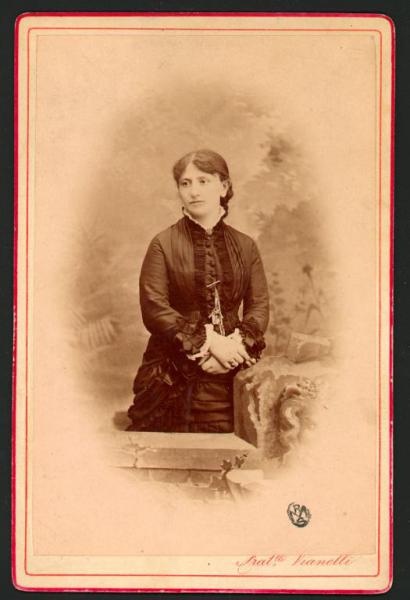 Ritratto femminile - Donna in piedi con acconciatura raccolta, in piedi dietro un finto muretto