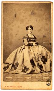 Ritratto femminile - Donna in abito ricamato seduta accanto a un tavolino tondo