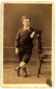 Ritratto infantile - Bambino in piedi con panataloni corti e stivaletti