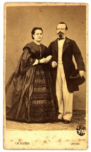 Ritratto di coppia - Donna con acconciatura raccolta e uomo con baffi e una tuba in mano, entrambi in piedi