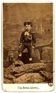 Ritratto infantile - Bambino vestito alla marinara in piedi su un finto masso