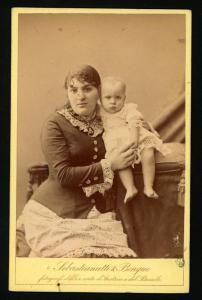 Ritratto di famiglia - Giovane donna con bambino con camiciola e piedi nudi appoggiato su un cuscino