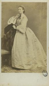 Ritratto femminile - Donna in abito chiaro, in piedi, appoggiata allo schienale di una sedia