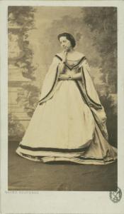 Ritratto femminile - Donna in abito chiaro, in piedi con la mano destra al volto