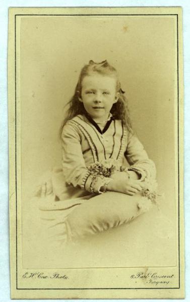 Ritratto infantile - Bambina seduta con in mano un mazzolino di fiori