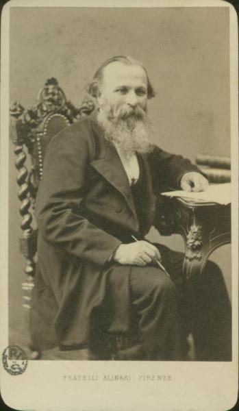 Ritratto maschile - Uomo anziano con barba seduto a un tavolo su cui è poggiato un foglio