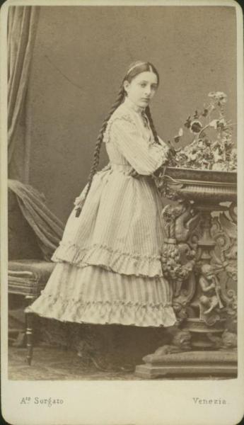 Ritratto femminile - Giovane con trecce, in piedi appoggiata a un portavaso a trepiede con una pianta d'edera