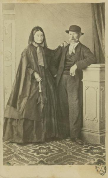 Ritratto di coppia - Donna appoggiata all'uomo, entrambi in piedi su un tappeto