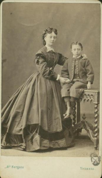 Ritratto di famiglia - Madre in piedi accanto al bambino seduto su un tavolo