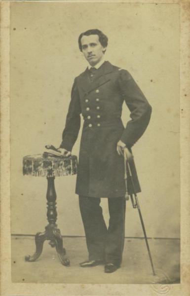 Ritratto maschile - Militare - Giovane in uniformein piedi con la spada al fianco, appoggiato ad un tavolo