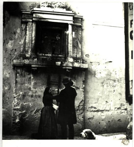 Roma (?) - Madre, padre e bambino davanti a un'edicola votiva in una strada