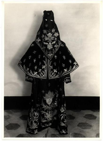 Genova (?). Abbigliamento da confraternita composto da tunica, mantellina e copricapo in seta scura ricamata.