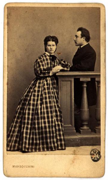 Ritratto di coppia - Donna in abito a quadri e uomo di profilo dietro una balaustra