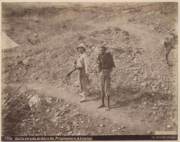 Ritratto di gruppo - Soldato italiano e guerriero abissino fatto prigioniero - Sulla strada per Ghinda