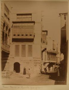 Egitto - Il Cairo - Centro storico - Una strada - Abitazioni - Balcone ligneo aggettante detto moucharabia - Cinque uomini - Cumulo di pietre spacccate - Donna con cesta in testa