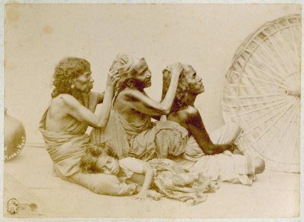 Scena di genere - Tre donne indiane, sedute una dietro l'altra si controllano i capelli - Una bambina dorme sulle ginocchia della donna di sinistra