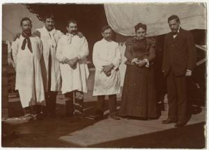 Ritratto di gruppo - Coppia con quattro uomini in abiti da lavoro, camice - Esterno