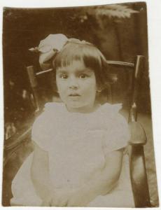Ritratto infantile - Bambina seduta con fiore in testa