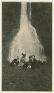 Ritratto di gruppo - Elvira Lazzaroni con uomo e altra coppia seduti nel prato davanti a una cascata d'acqua