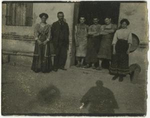 Esterno, cortile - Ritratto di gruppo - Coppia con ragazza, famiglia e tre uomini, lavoratori - Ombra di Leopoldo Metlicovitz