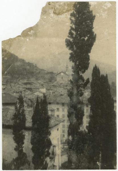 Paese montano - Veduta - Edifici residenziali - Chiesa - Cipressi - Montagna sullo sfondo