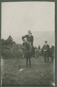 Ritratto maschile - Uomo in sella a un cavallo - Uomini in secondo piano - Esterno - Prato