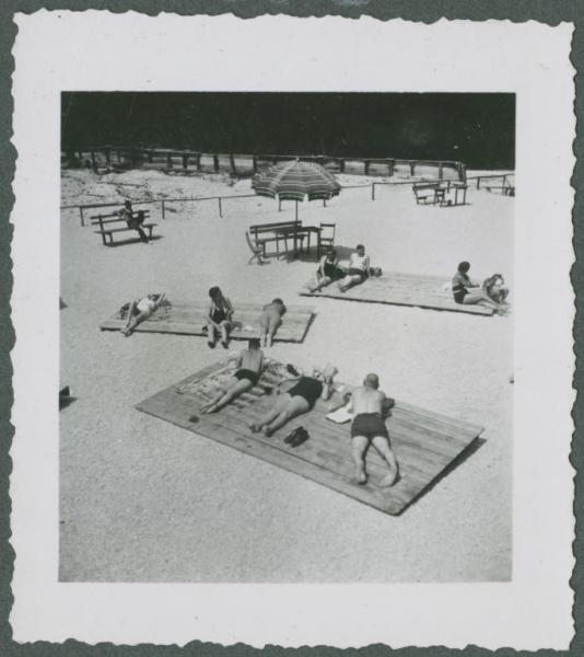 Braies - Lago di Braies - Spiaggia - Uomini e donne sdraiati, bagnanti a prendere il sole - Ombrellone
