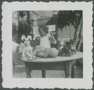 Ritratto infantile - Rita Di Stefano seduta sul tavolo - Giocattoli - Varenna - Casa - Giardino