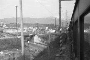 Viaggio verso l'Africa. Vedute dal finestrino del treno: militari affacciati che osservano un paesaggio urbano