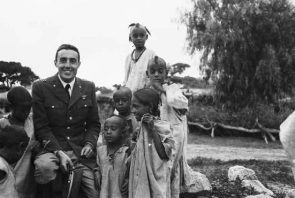 Viaggio in Africa. Ritratto di gruppo - militare italiano con un gruppo di bambini indigeni - Carletti