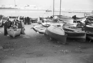 Viaggio verso l'Africa. Napoli: barche da pesca tirate in secca, pescatori e la città sullo sfondo
