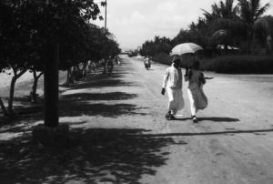 Viaggio in Africa. Massaua - lungomare - viale alberato - indigeni si riparano dal sole con l'ombrello
