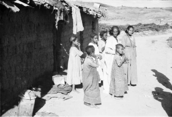 Viaggio in Africa. Villaggio - scene di vita quotidiana - gruppo di donne e bambini indigeni all'esterno della loro abitazione