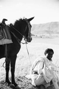 Viaggio in Africa. Militare indigeno seduto per terra durante una pausa di riposo