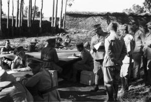 Viaggio in Africa. Militari italiani siedono a un tavolo posizionato in un campo durante una riunione