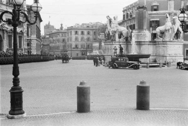 Patti di Roma. Piazza del Quirinale assiepata di persone che osservano la sfilata di automobili e carrozze