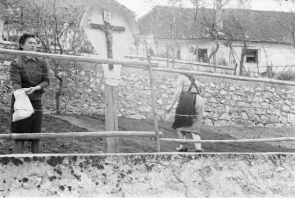 Viaggio in Jugoslavia. Postumia - edicola votiva - donna semina un orto