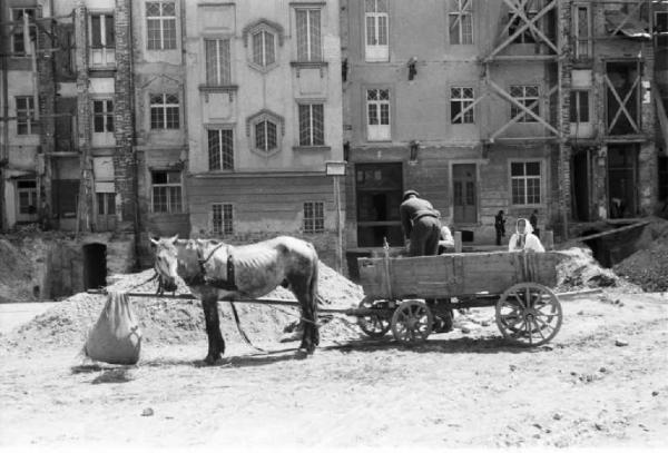 Viaggio in Jugoslavia. Zagabria, carretto trainato da un cavallo in sosta davanti a edifici in costruzione