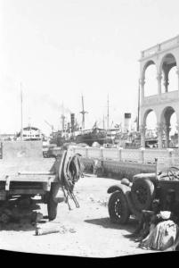 Viaggio in Africa. Massaua: scorcio del porto con autocarri militari italiani e piroscafi sullo sfondo
