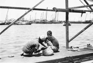 Viaggio in Africa. Porto di Massaua: due ragazzini indigeni pescano in banchina