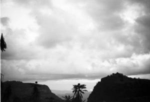 Viaggio in Africa. Paesaggio africano: rocce, alberi di palma e il cielo percorso da nuvole