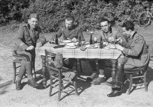 Ritratto di gruppo, quattro militari attorno a una tavola imbandita