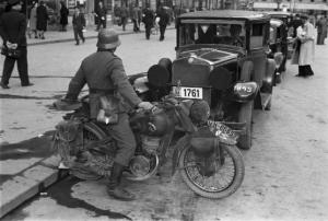 Viaggio in Jugoslavia. Zagabria: militare in motocicletta e autocarri militari parcheggiati lungo il ciglio della strada