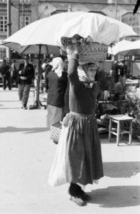 Viaggio in Jugoslavia. Zagabria: il mercato. Donna croata che reca sulla testa una cesta coperta da un telo