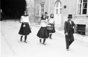Viaggio in Jugoslavia. Zagabria: donne croate in abiti tradizionali e uomo con la tuba a passeggio per una via cittadina