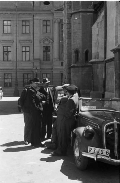 Viaggio in Jugoslavia. Zagabria: gruppo di persone che conversano accanto a una macchina (marca Skoda)