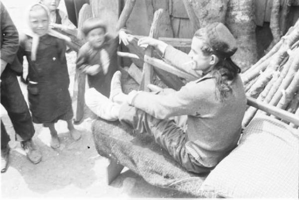 Viaggio in Jugoslavia. Vrhovine. Giovane uomo con piede fasciato e bambini sorridenti